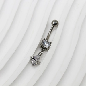 Détail macro du piercing nombril argent foncé avec zircons en poire et pendentif flèche