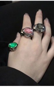 Macro shot of three vintage punk style finger watch rings with colorful gemstones