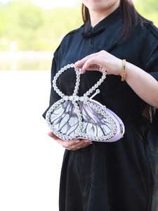 Close-up of a purple butterfly shaped evening bag with sparkling rhinestones and details