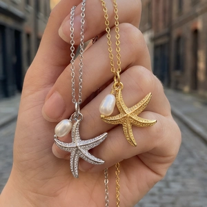 Detailed macro view of 18K gold and silver starfish pendants with elegant white pearls