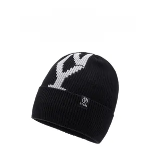 Detail der schwarzen Rippstrick-Beanie mit weißem Y-Muster und gewebtem Markenetikett