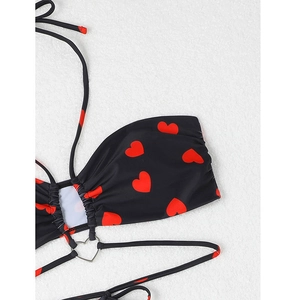 Détail du haut de bikini licou noir avec cœurs rouges et connecteur en métal
