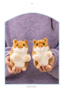 Close-up of small stuffed hamster plush toy held in hand showing soft fur texture