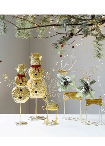 Detail of gold metal snowman and reindeer desk decor with pine cones and red scarf