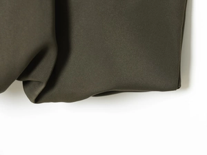 Close-up of olive green halter top fabric showing fine texture and soft drape
