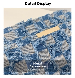 Détail de la toile denim à damier bleu avec bords effilochés et plaque en métal doré