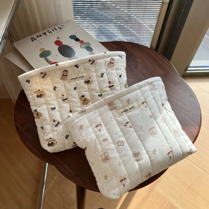 Detailed close-up of quilted cotton cosmetic bags with cute cartoon animal prints and labels