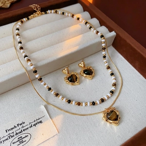 Gold plated tiger eye heart necklace and earring set on a soft jewelry display tray