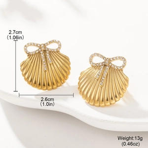 Close-up of golden shell earrings with rhinestone bows showing precise measurements