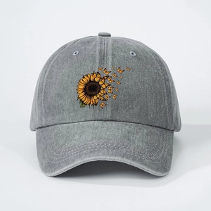 Detail of sunflower and butterfly print on vintage washed grey denim baseball cap