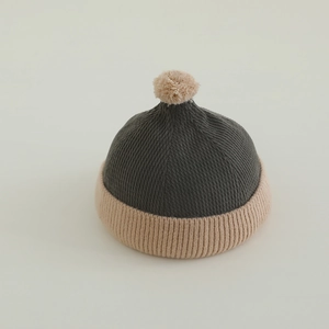 Detailed macro view of soft ribbed texture on baby knit beanie with pom-pom