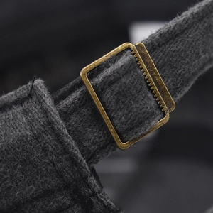 Detailed macro view of an adjustable bronze metal buckle on a charcoal washed baseball cap