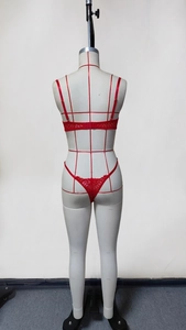 Back view of a red floral lace lingerie set featuring a thong and strappy bra on mannequin