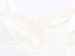 Gros plan d'un crop top blanc avec détails de nœuds en corde tressée beige
