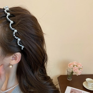 Detail of wavy tooth headband with lustrous pearls on an elegant female model