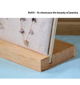 Detailed close-up of a necklace with purple stones on a wooden jewelry display stand