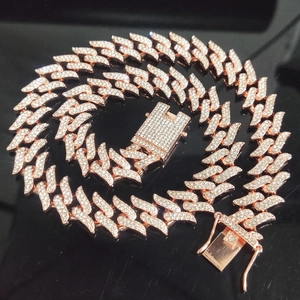 Macro shot of rose gold iced out Cuban link chain with sparkling pavé rhinestones