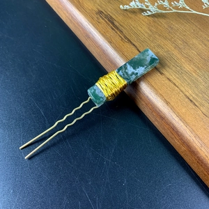 Detailed close-up of handmade green moss agate gemstone hair pin with gold wire wrapping
