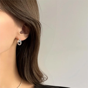 Minimalist 925 sterling silver curved hoop earrings on model with sleek metallic finish