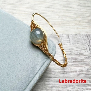 Macro detail of handmade 14K gold wrapped wire bracelet with iridescent Labradorite stone