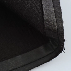 Detalle macro del tejido negro y la costura del dobladillo en cuero sintético
