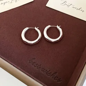 Silver hoop earrings with irregular organic texture and minimalist geometric design