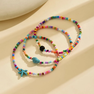 Detailed macro of 3-piece bohemian anklet set with colorful beads and starfish charms