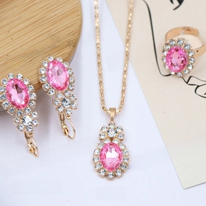 Detail view of pink rhinestone necklace, earrings and ring jewelry set with gold plating