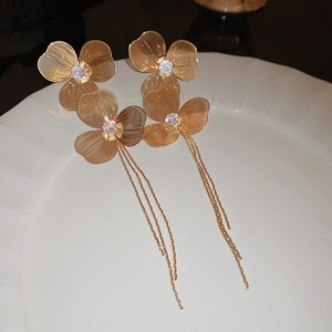 Elegant gold flower tassel earrings with woven metal petals and crystal center