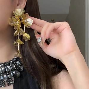Elegant vintage long gold flower tassel earrings with crystals on a female model