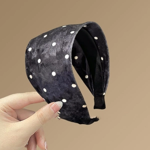 Détail du tissu en velours doux et du motif classique à pois blancs sur le bandeau large pour femme