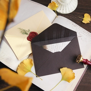 Vintage linen textured envelope set with wax seal and stamp on retro desk background