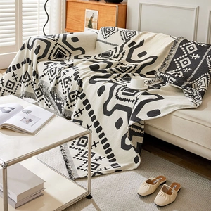 Bohemian black and white geometric chenille sofa cover with fringed edges in living room