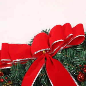Christmas wreath with red velvet bows and pine needles for holiday decoration