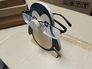 Macro shot of a wooden penguin glasses holder showcasing how to support eyeglasses