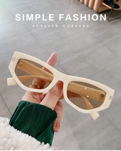 Detail of cream-white rectangle sunglasses featuring gold double-stud accents on the frame