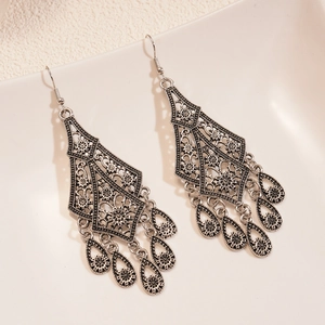 Detailed close-up of antique silver drop earrings with mandala flower patterns