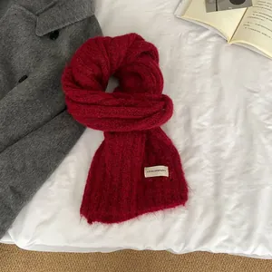 Detail of red wool knit scarf with soft fluffy texture and LOVELORN PUPPY woven label