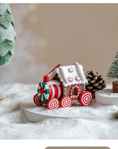 Macro shot of candy-themed Christmas train ornament on snow background decoration