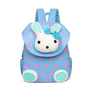 Detail of blue canvas kids backpack with pink polka dots and plush bunny decoration
