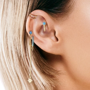 Close-up of S925 silver star tassel earrings and evil eye studs with turquoise detail