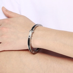 Detail of punk style stainless steel bracelet with black inlay and rivets on wrist