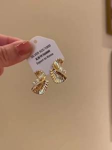 Detailed close-up of gold fan-shaped earrings featuring S925 silver and cubic zirconia