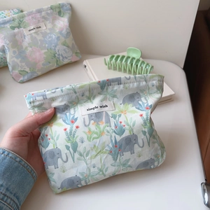 Detail of floral and elephant print fabric makeup bag featuring simple wish woven label