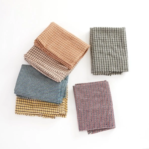 Detail of five houndstooth scarves with fringes in brown, beige, blue, yellow and red