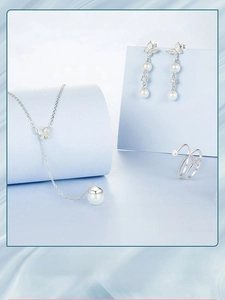 Macro detail of S925 silver butterfly jewelry set with pearls and tassel necklace