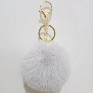 Detail of grey faux rabbit fur ball keychain with gold-tone lobster clasp and metal ring