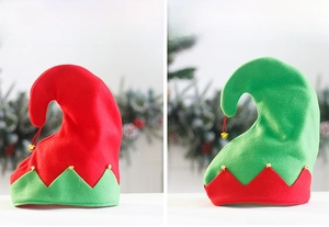 Detail view of red and green velvet Christmas elf hats with gold bells for holiday parties