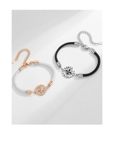 Détail de bracelets de couple ajustables avec étoile boussole et anneaux gravés