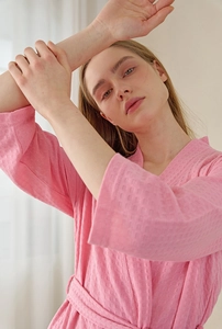 Detailed view of pink waffle knit bathrobe with V-neck design and soft honeycomb texture